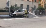 Fiamme dal cofano di un'auto in pieno centro