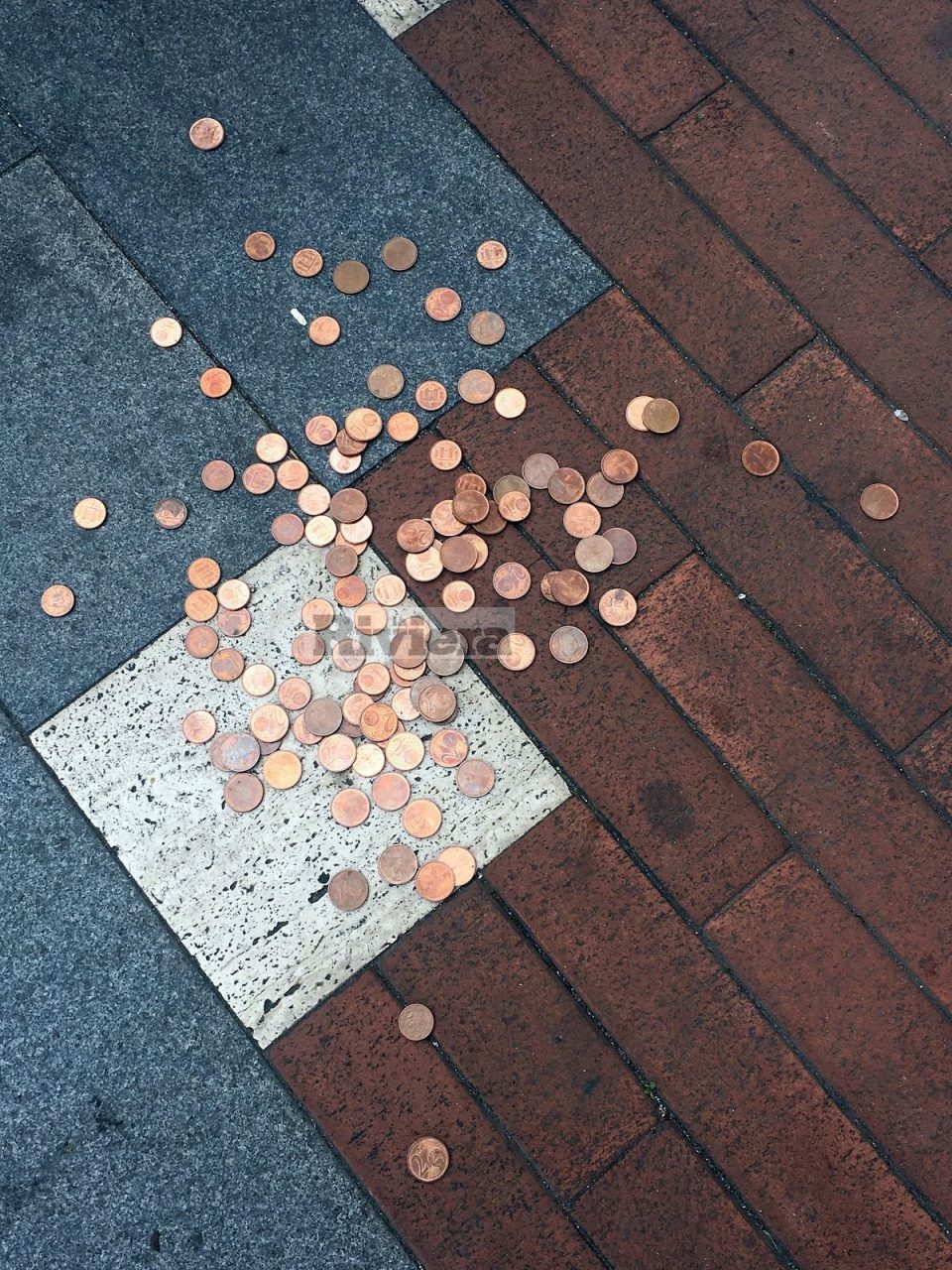 Decine di monetine da 2 centesimi di euro gettate per strada e nessuno le raccoglie