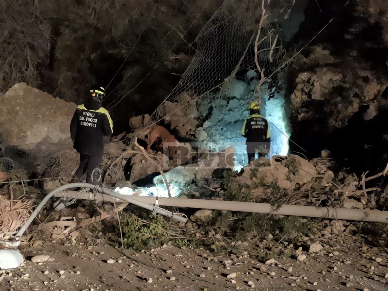 L’unità cinofila scava sotto la frana alla ricerca di persone