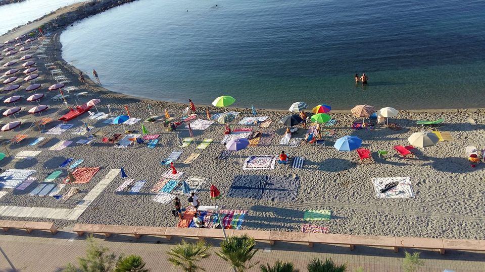 L’asciugamano in spiaggia all’alba, per assicurarsi il posto e il distanziamento sociale