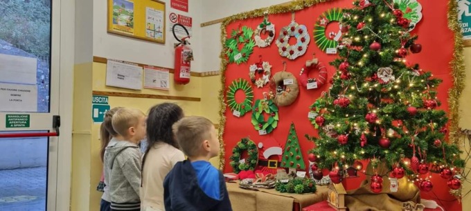 Bimbi regalando ghirlande di Natale ai commercianti