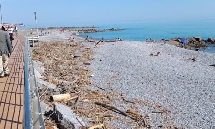 Turisti in spiaggia tra copertoni e lamiere