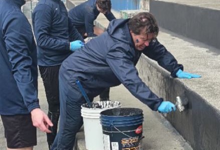 Mister e calciatori dell’Imperia dipingono di neroazzurro le gradinate del Ciccione