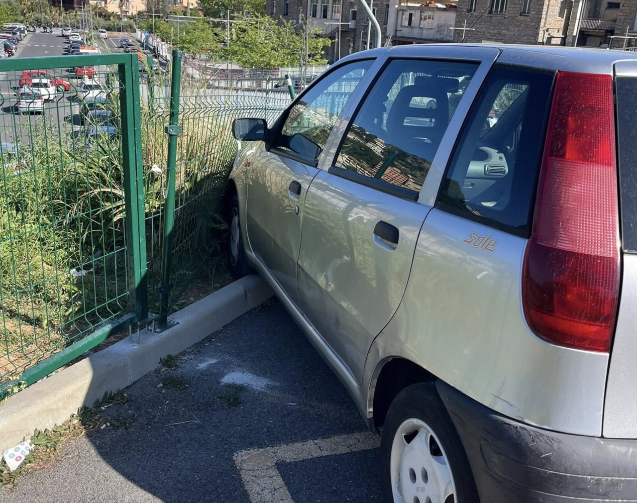 Posteggia l’auto senza il freno a mano e se ne va… e la vettura sfonda la recizione della nuova area cani